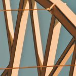 Close-up view of a steel structure with geometric design against a clear sky.